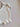 Mila Pointelle Tie Romper Snow knitted in a signature pointelle design featuring a sleeveless bodysuit shape shown in an angled view.