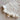 Mila Pointelle Tie Romper Snow knitted in a signature pointelle design featuring snap openings for easy nappy changes and leg frills shown in a close up view.