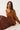 Woman wearing a brown sweater and leopard print skirt on a white background