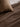 Close-up detail of the hand-block printed mocha chequered pattern on pure linen, resting on a brown waffle-weave bedding blanket.