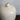 Close-up detail of the smooth glazed ceramic surface and narrow neck opening of the off-white porcelain vase.
