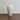Straight-on front view displaying the sculptural, gently tapering proportions of the off-white porcelain narrow neck vase.