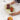 Person holding a decorative green onyx oval tray with fruits on a marble surface, featuring the brand 'Radical'.