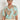 Perceive Top in mint kgari front view featuring a v-neckline with loop trim and short raglan sleeves.