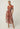 Perla sheer print dress in amber vine worn by a model, featuring lightweight viscose fabric and an exclusive floral pattern.