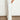 Phase Pant side angle view highlighting the clean refined finish, soft white hue, full-length cut, and side seam pocket detail.