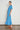 Poem Dress Lagoon shown from the side profile highlighting the midi length and flattering silhouette.