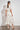 Poem Dress Painterly Bloom crafted in a lyocell linen blend featuring scattered florals, short tulip sleeves, and lace inserts shown in a back view.