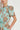Close-up detail of the Quote Dress in mint kgari showing the button-through design, short sleeves with gathers, and cotton poplin fabric.