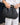 Raffia Clutch with gold chain in black featuring a snap handle closure and a gold chain strap shown in a crossbody view.