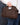 Raffia Clutch with gold chain in chocolate featuring a snap handle closure and woven texture shown in a close up view.