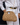 Raffia Clutch with gold chain in natural featuring a snap handle closure and a gold chain strap shown in a crossbody view.