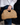 Raffia Clutch with gold chain in natural featuring a snap handle closure shown held by the handle.