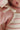 Raised Stripe Tie Romper Sweetpea knitted in a raised sweetpea stripe on a soft snow base featuring adjustable tie shoulders shown in a close up view.
