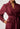 Maroon dress with intricate lace detailing on a plain background