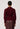 Person wearing a burgundy sweater and brown pants on a white background