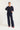 Woman wearing a navy sweater and pants on a white background