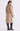 Woman wearing a beige coat with fur collar on a white background