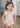 Ruby Romper in beige featuring a smocked bodice, ruffle straps, and a bubbled shape.