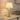 Sage Ball Lamp with Natural Shade styled on a light wooden tabletop next to a decorative bowl, casting a warm glow.