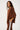 Woman wearing a brown outfit with a white stripe on a white background