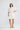 Full-length front view of a model wearing the Sandra Dress in Porcelain showing its short length and regular fit.