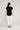 Sandra tee black featuring a round neckline, turn-back short sleeves, and a curved hem, shown from the back view.