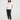 Sandra Tee in white front view, featuring a relaxed fit peached jersey design with a round neckline, turn-back short sleeves, and curved hem paired with dark pants.