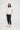 Sandra Tee in white front view, featuring a relaxed fit peached jersey design with a round neckline, turn-back short sleeves, and curved hem paired with dark pants.