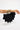 Santana Bag Black styled on the wrist showcasing its sculptural silhouette and metallic top handles.