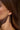 Lifestyle close-up view of a model wearing the gold-plated Sierra Earrings featuring sky blue topaz and citrine stones.