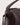 Close-up of the Small Bolster Bag in mahogany waxy leather highlighting antique brass-toned hardware and fixed handle attachment.
