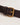 Close-up view of the adjustable leather strap and antique brass-toned buckle on the Small Bolster Bag in mahogany.