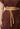 Close-up of the removable waist belt and button detailing on the Solene rosewood dress.