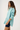 Woman wearing a light blue and green striped shirt on a white background
