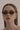 The Coco sunglasses in honey ochre featuring retro oval frames worn on a model.