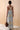 Back view of The Lynn dress showing the adjustable cross straps and sculptural resin buckle details.