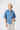 The White Place Kireina Beth Shirt in Mid Blue cord. Ladies lightweight corduroy utility shirt with a curved hemline and silver press stud buttons, showcasing relaxed everyday luxury style.