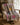 The White Place Saddle Club horse scarf in Pastels, showcasing a grey equestrian patchwork pattern with bright pink and yellow horses on a cozy white armchair.