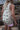 Back view of the reversible Tiki overalls showing the full island-girl print and adjustable strap design.
