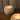 Close-up angled view of a burning Travertine soy candle highlighting the warm flame and smooth stone vessel texture.