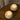 Top-down view of two burning Travertine candles in solid natural stone vessels.