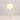 Illuminated Whisper White Ball Lamp showcasing a glowing natural fabric shade and stacked spherical white base.