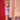Xena Pullover Tan close-up detail view highlighting the sleeve design and layered styling over a red background.