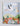 Story book page showing a stork delivering a baby bundle over a village.